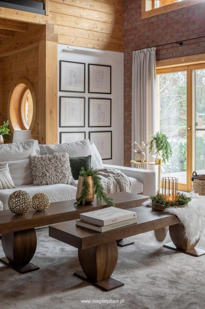luksusowy salon w drewnianym domu z białym wypoczynkiem i drewnianymi stolikami kawowymi projekt MG Wnętrza