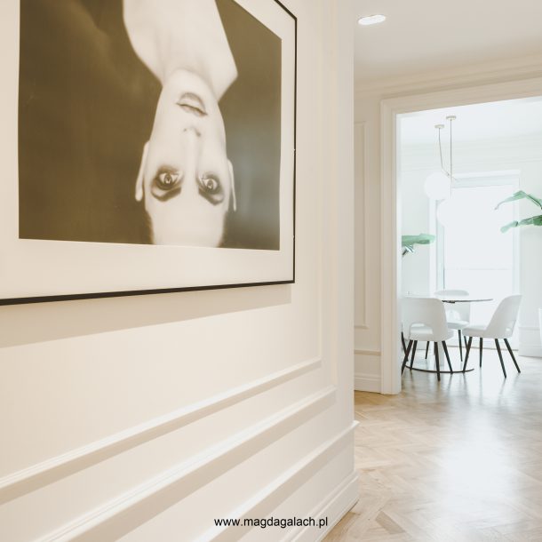 elegancki korytarz ze sztukaterią w biurze MG Wnętrza, białe krzesła i bananowce