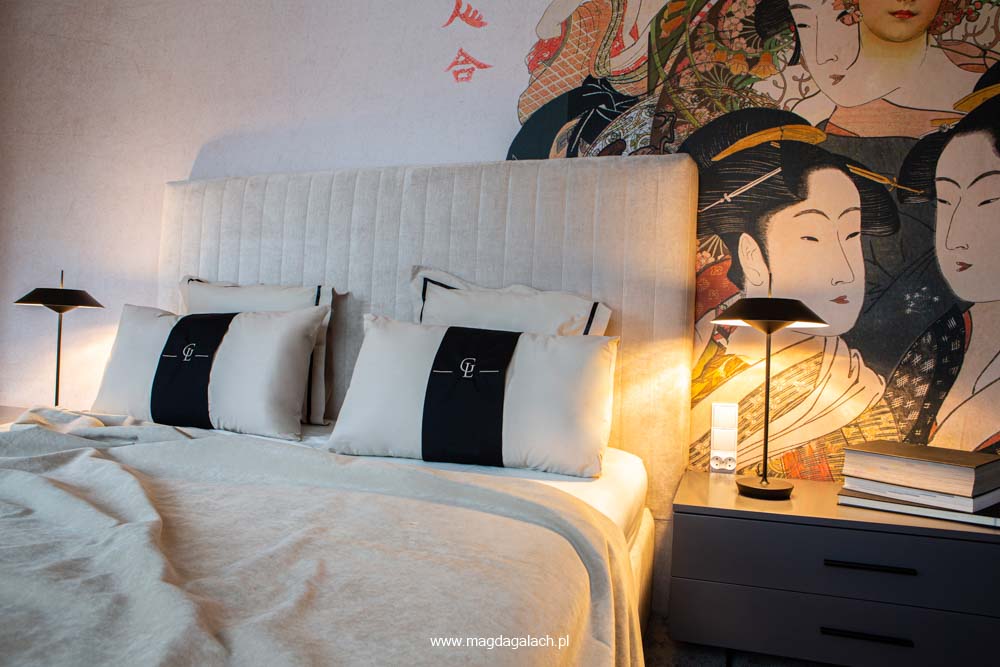 luksusowa sypialnia z tapetą z gejszami z beżowym aksamitnym łóżkiem oraz poduszkami z monogramem Magda Gałach